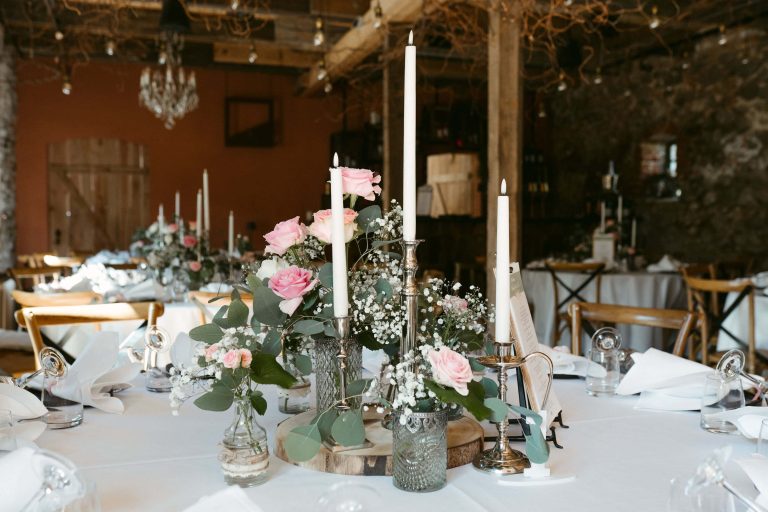 Hochzeitsdekoration auf Gut Leben in Brandenburg mit rosafarbenen Rosen, Kerzen und eleganten Kerzenhaltern