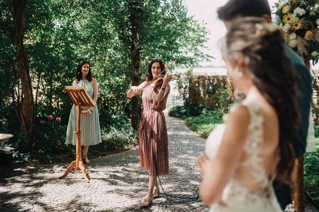 Violonista Lisa toca el violín en la boda francesa-alemana la melodía "L'hymne à l'amour".